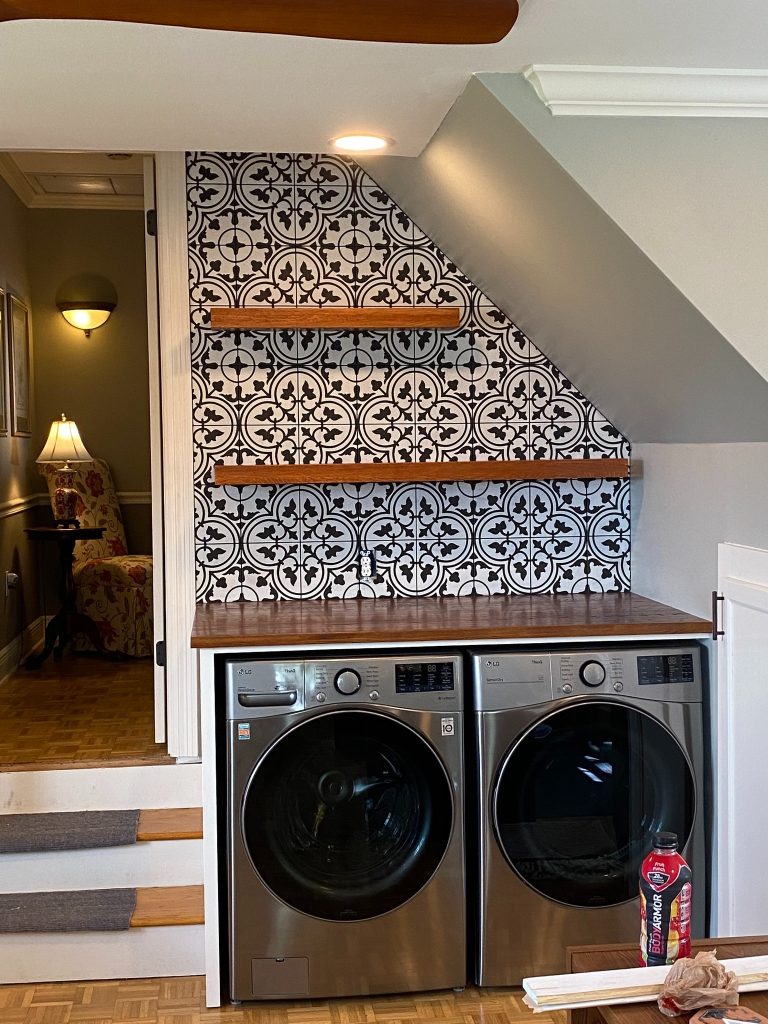 Custom Laundry Nook with Patterned Tile Accent Wall and Floating Wood Shelves