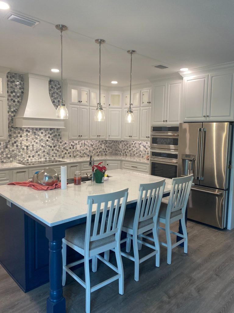 Refined Kitchen Feature Wall with Architectural Range Hood, Tall Pantry Cabinets, and Patterned Tile Accent