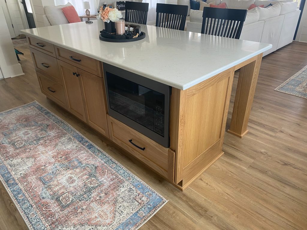 Modern Kitchen Island with Built-In Microwave and Light Wood Cabinetry