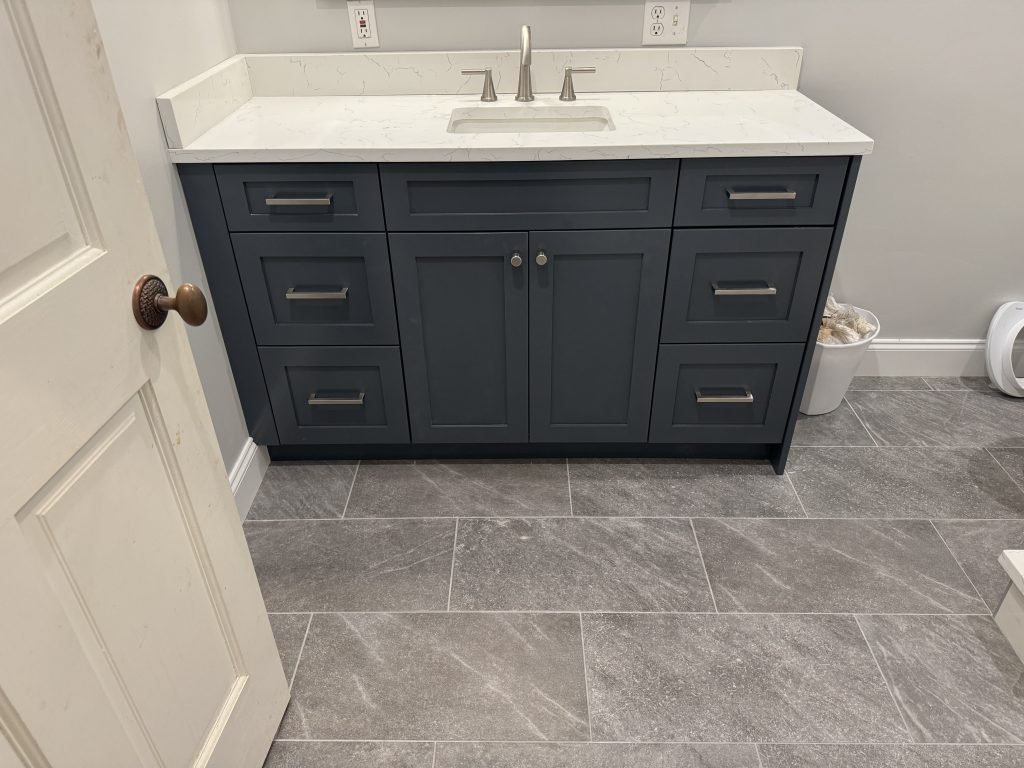 Dark Blue Bathroom Vanity with White Countertop and Silver Hardware