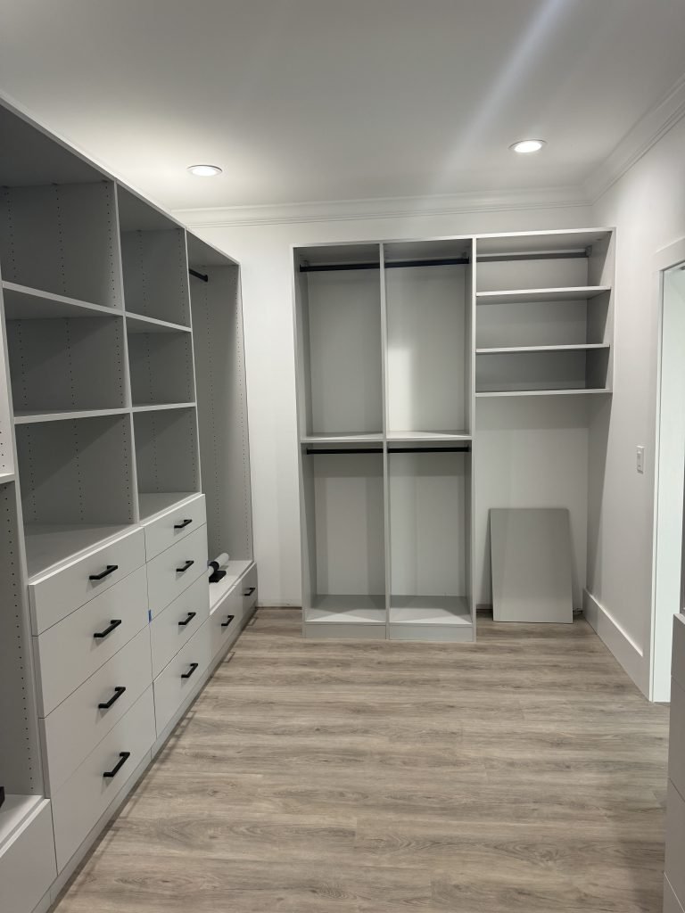 Spacious Walk-In Closet Under Construction with Light Gray Organizers and Wood-Look Flooring